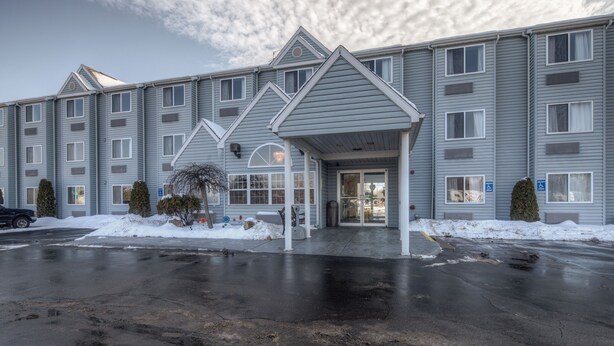 A multi-story hotel with a covered entrance and a parking lot. - Quality Inn Mount Pleasant (Mount Pleasant)