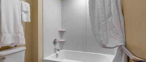 Une salle de bain avec une baignoire, des toilettes et un porte-serviettes.