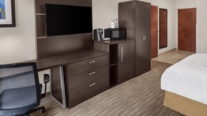 A hotel room with a bed, a desk with a chair, a TV, a microwave, and a wardrobe. - Holiday Inn Express & Suites Asheville SW - Outlet Ctr Area by IHG (Asheville)