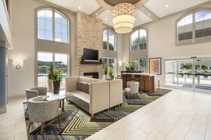 A spacious living area with a fireplace, comfortable seating, and large windows offering views of the outdoors.
