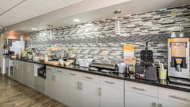Una cocina moderna con salpicadero de azulejos, una zona de café y un fabricante de gofres.