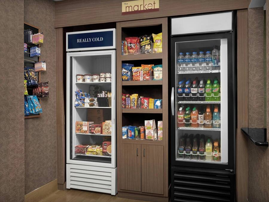 Vitrine refrigerada com a inscrição "REALLY COLD", contendo lanches e bebidas.