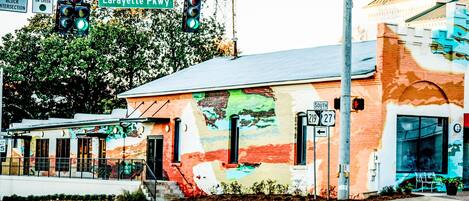 Un edificio con un mural colorido, un cartel que indica Lafayette Pkwy y un escaparate con toldo rojo.