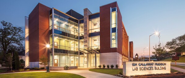 The exterior of the Ida Callaway Hudson Lab Sciences Building with a modern architectural design, featuring large glass windows and brick walls.