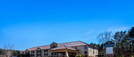 A hotel with a covered entrance, multiple floors, and a sign indicating it is a La Quinta Inn & Suites.