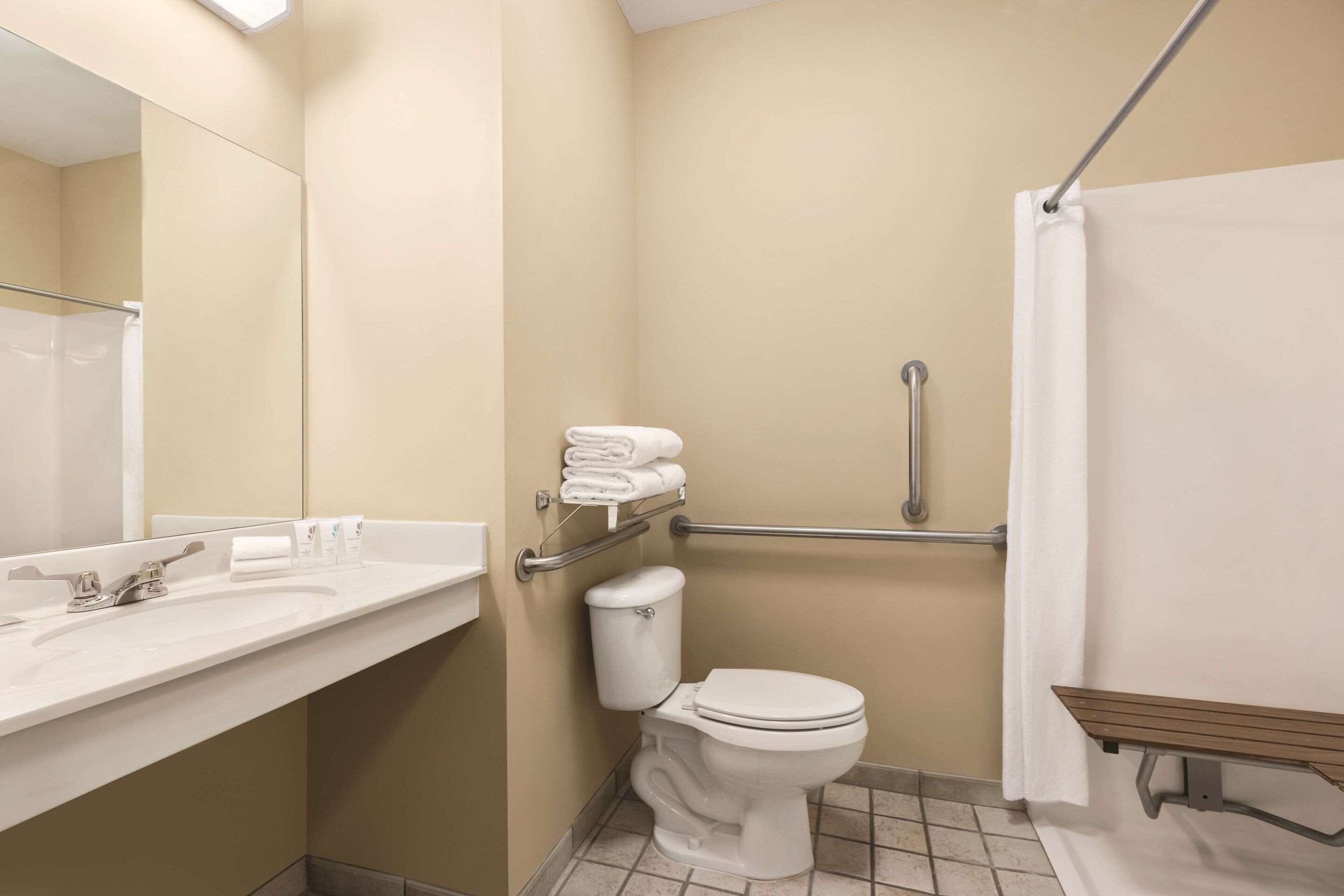 A bathroom with a toilet, sink, and shower area.