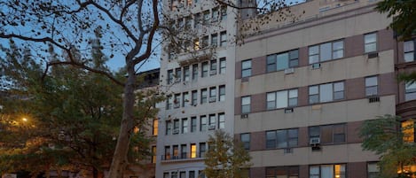 A multi-story building with a brick facade, large windows, and a visible entrance.
