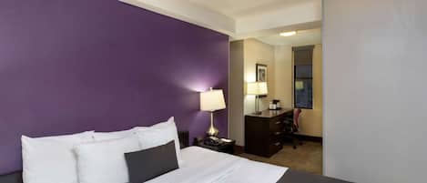 Una camera d'albergo con un letto grande, una scrivania e una sedia.