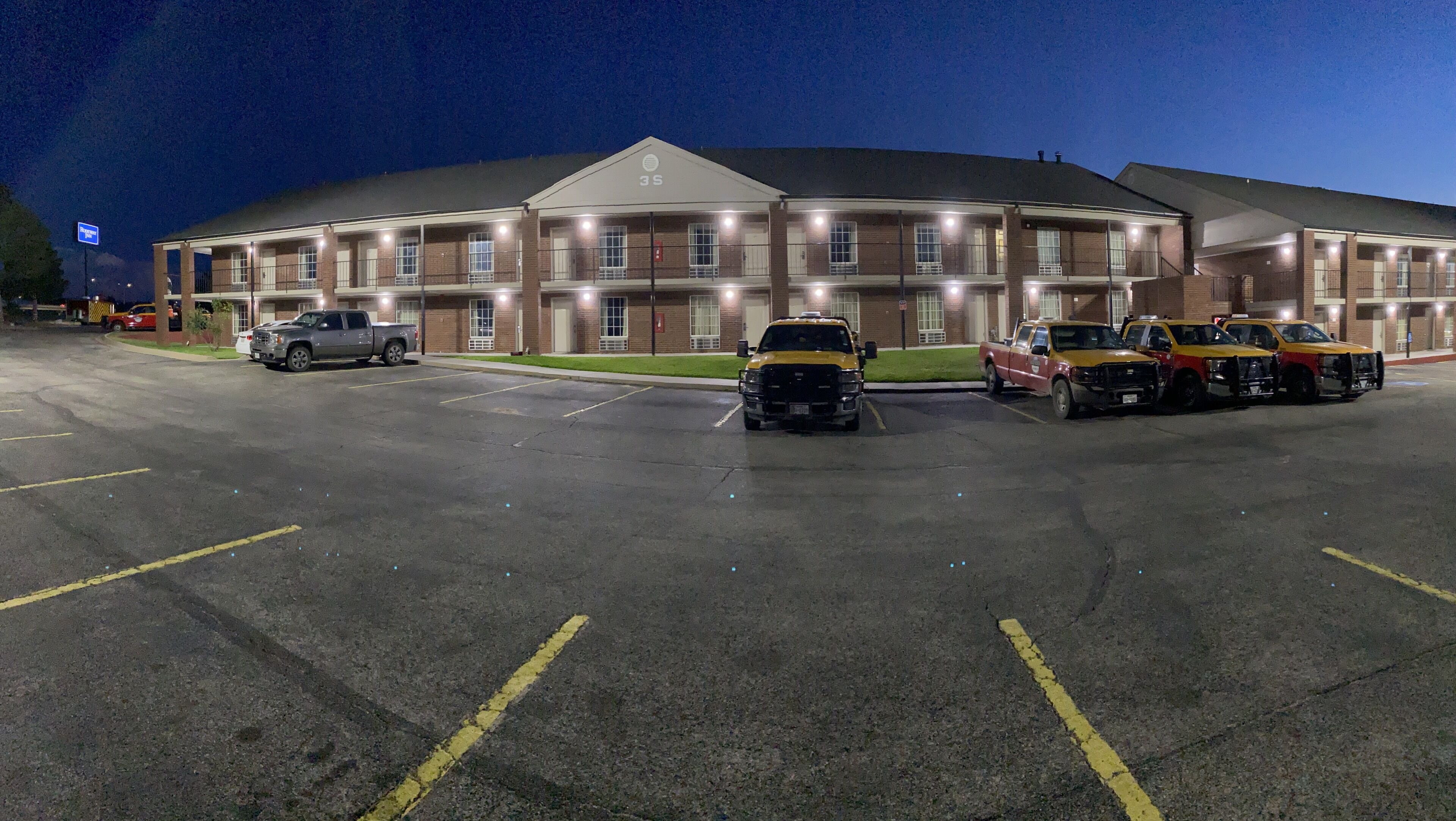 Een meerlaags hotel met een parkeerplaats.