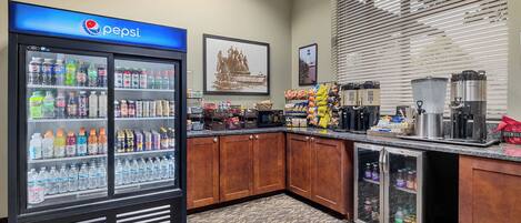 A kitchenette with a Pepsi refrigerator, coffee makers, and snack dispensers.