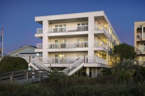 A multi-story hotel with balconies, a staircase, and a flag.