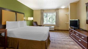 A hotel room with a large bed, a television, a desk, and a window with curtains. - Extended Stay America Suites Washington DC Landover (Upper Marlboro)