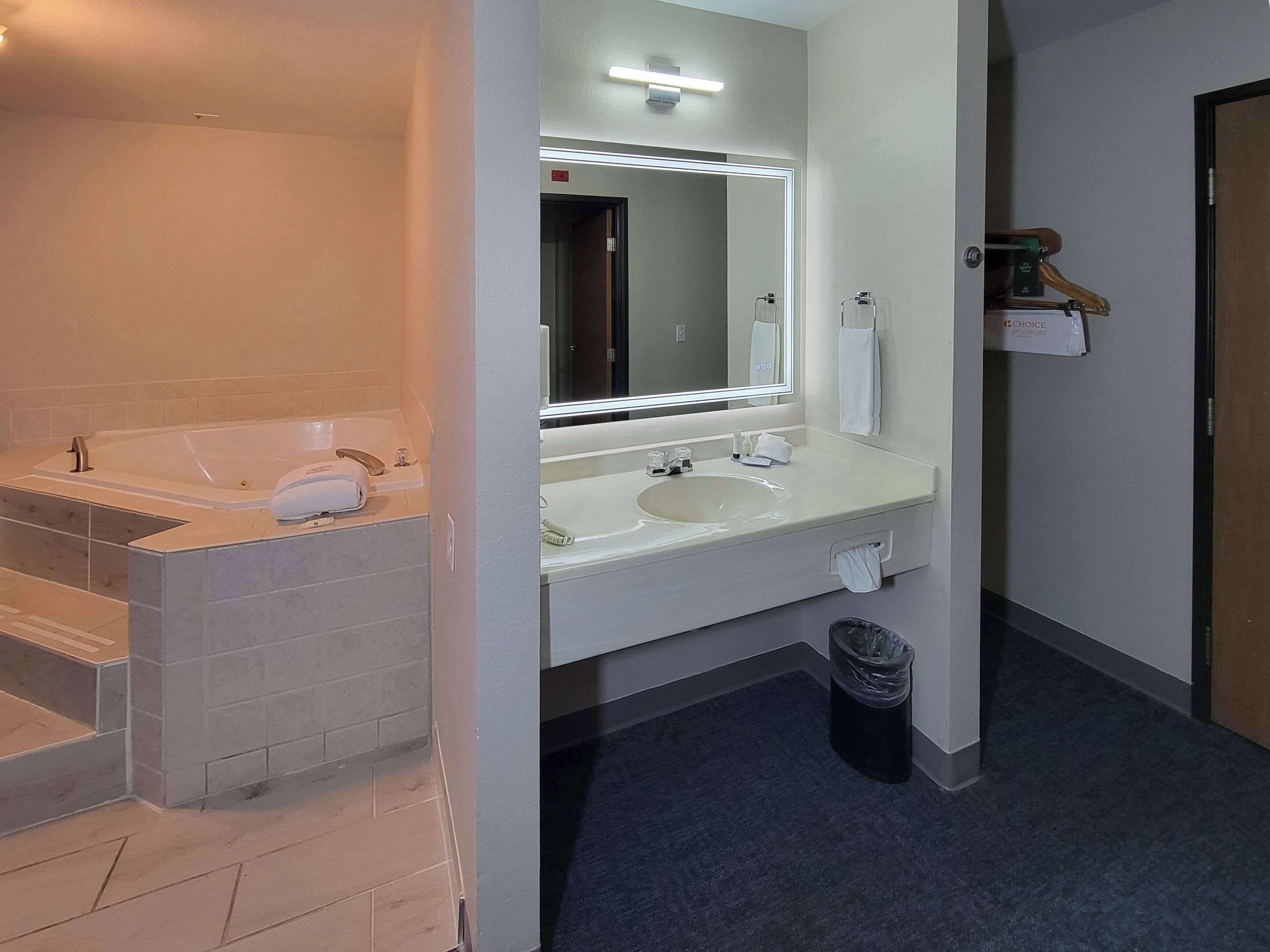 A modern bathroom with a bathtub, a sink, and a mirror.