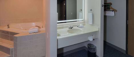 A modern bathroom with a bathtub, a sink, and a mirror.