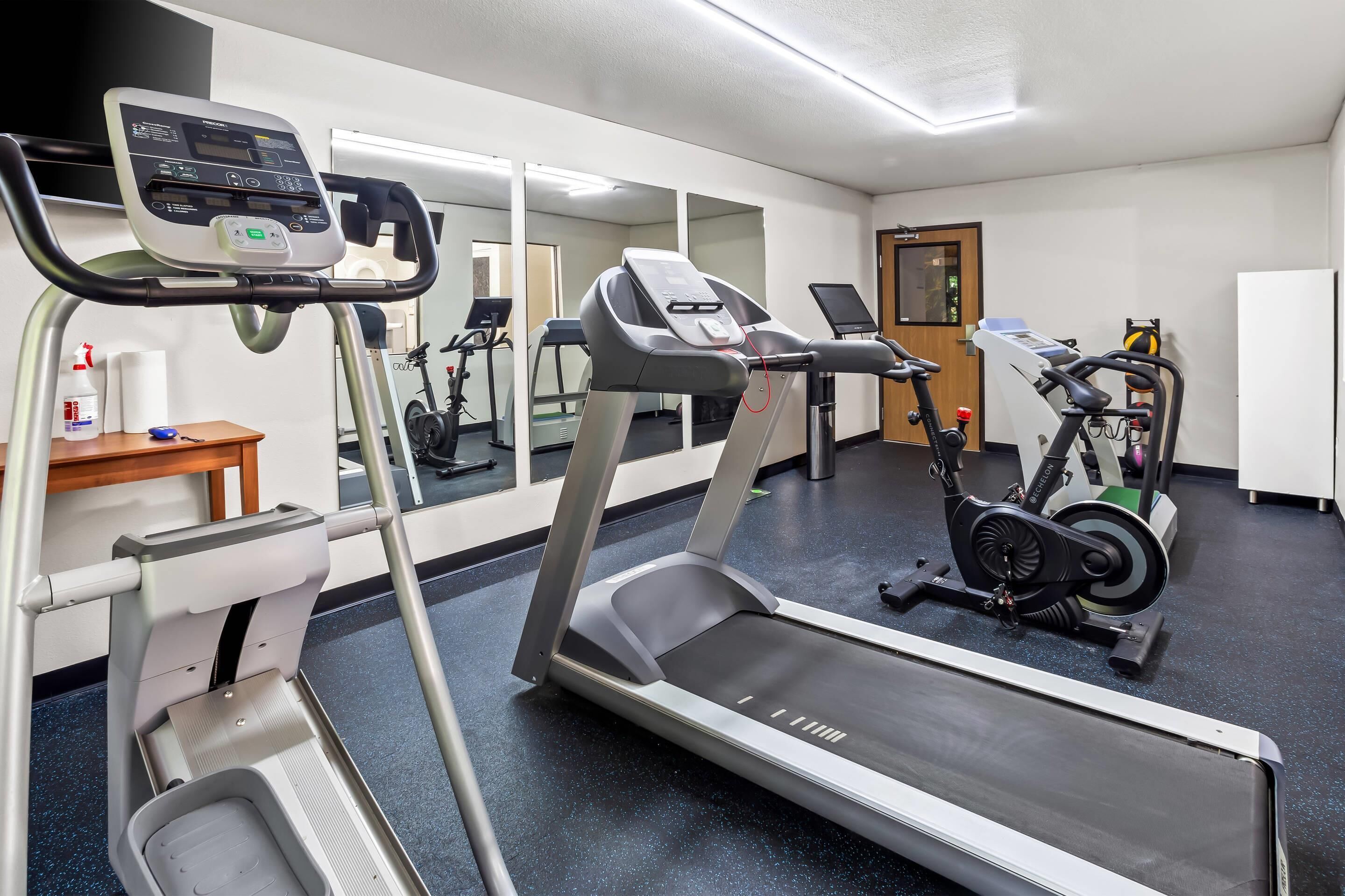 A gym with treadmills, an elliptical, and a stationary bike.