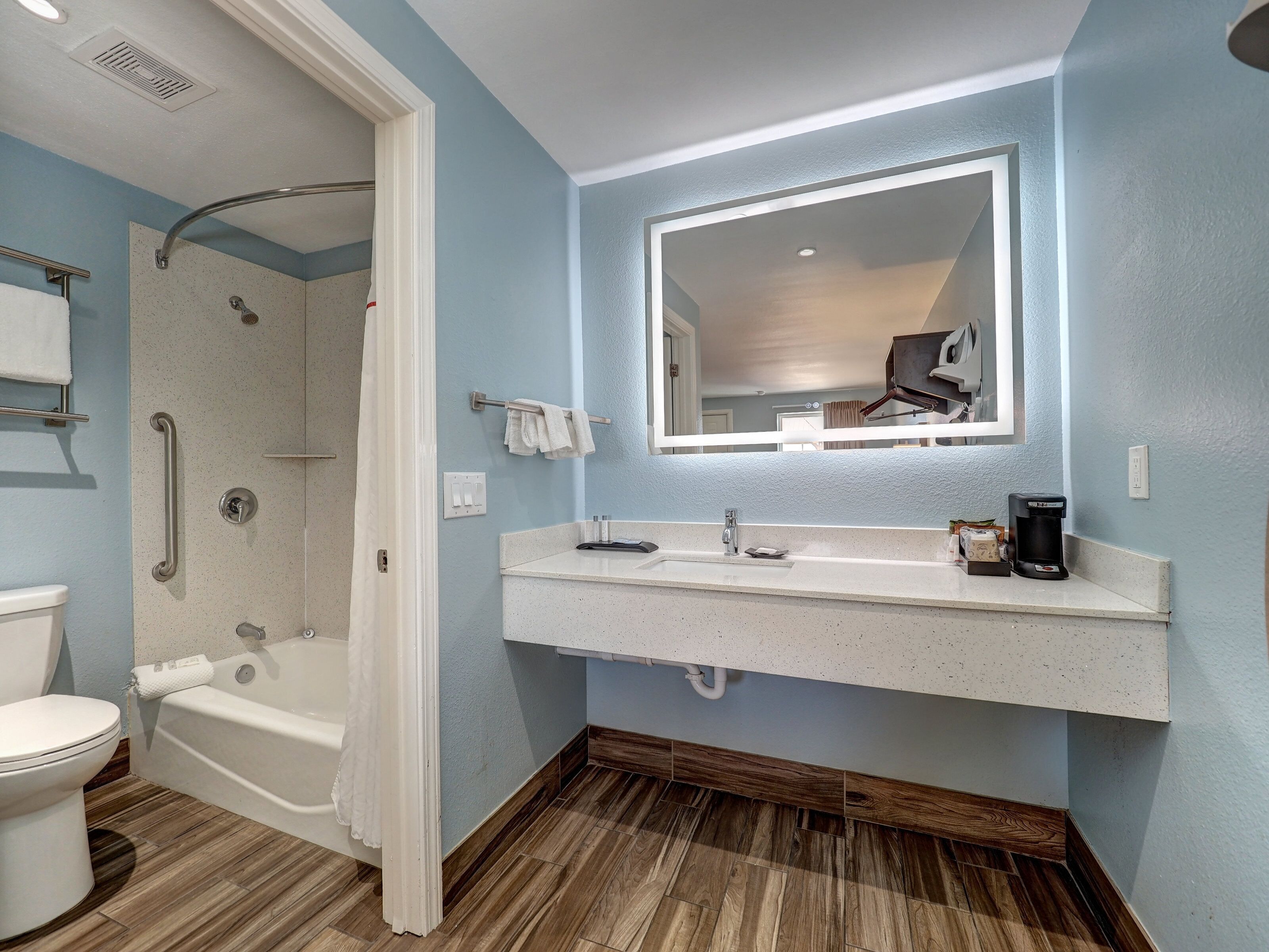 A bathroom with a shower, toilet, and sink.