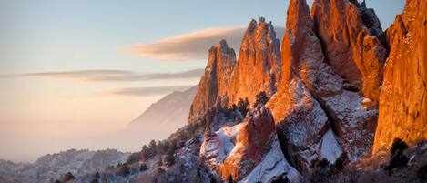A mountainous landscape with prominent rock formations during sunset.