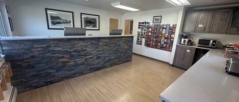A reception area with a stone counter, framed pictures on the wall, and a bulletin board with various items.