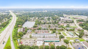 A large building with multiple parking lots and a river in the background. - Siegel Select Baton Rouge (Baton Rouge)