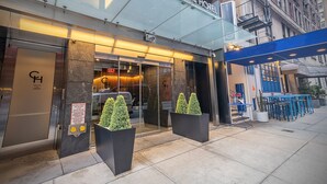Carnegie Hotel set med glasefterdør, store plantekasser og en blå markise.