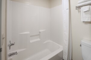 Un baño con una bañera blanca, un inodoro y un perchero para toallas.
