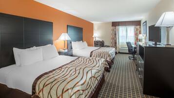 A hotel room with two beds, a desk, a chair, and a TV.