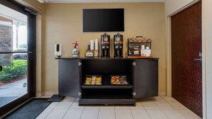 A reception area with a black counter, a mounted television, and two large beverage dispensers. - Extended Stay America Suites Ft Lauderdale Cyp Crk Andrews A (Oakland Park)