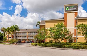 A hotel with a sign for Extended Stay America, featuring a multi-story building with balconies and a parking lot. - Extended Stay America Suites Ft Lauderdale Cyp Crk Andrews A (Oakland Park)