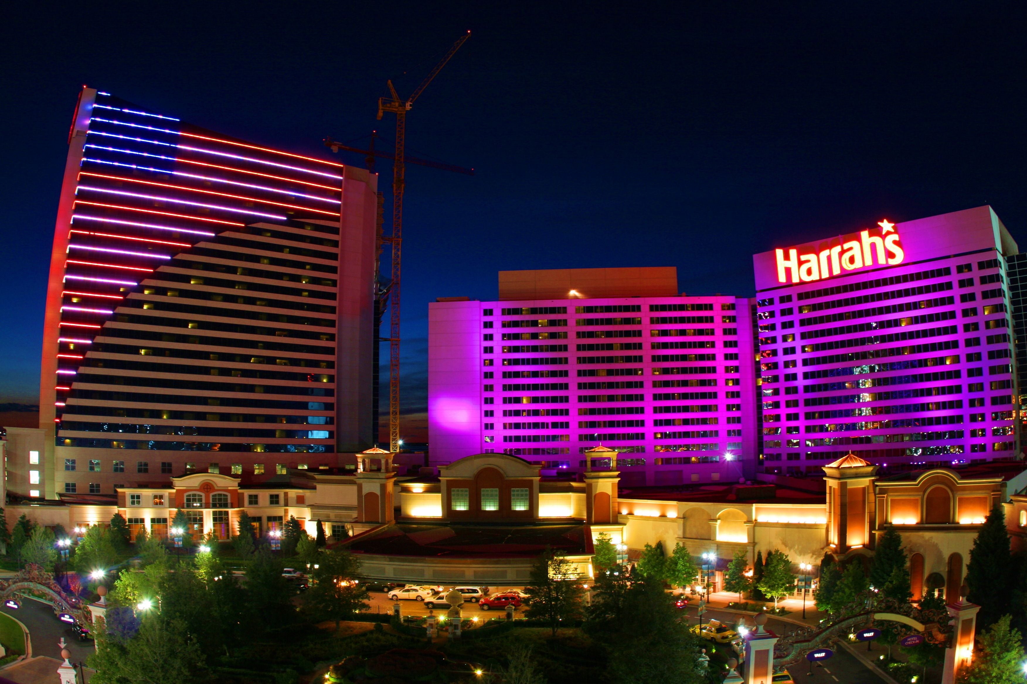 Un hôtel reconnaissable à son grand panneau « Harrah’s », un bâtiment imposant au design moderne, et une grue de construction bien visible en arrière-plan.