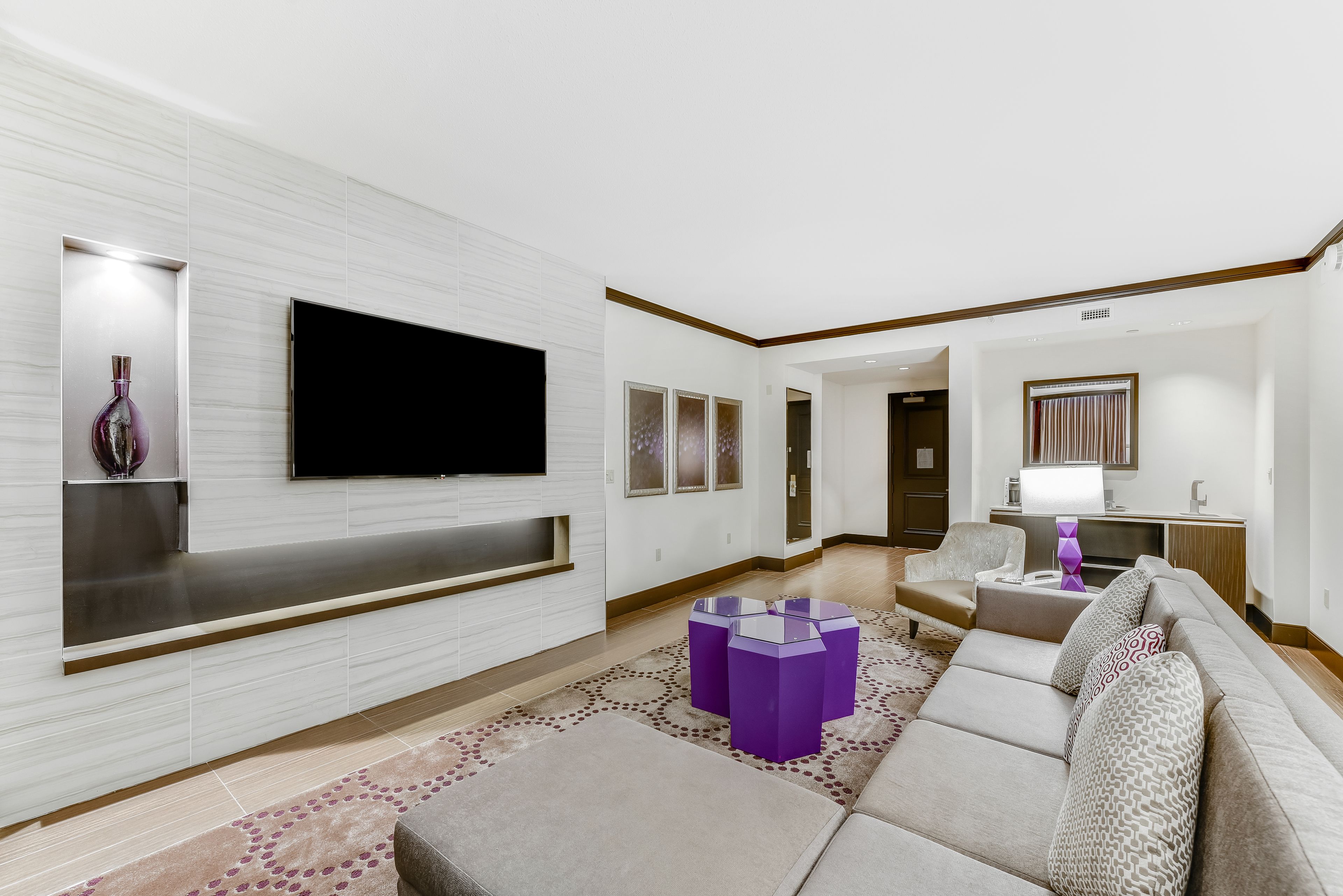 Ein modernes Wohnzimmer mit Fernseher, einer Couch und einem Couchtisch.