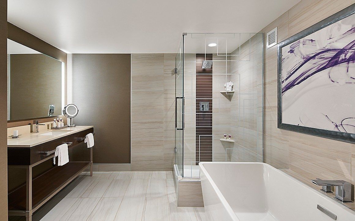 Une salle de bain moderne avec un grand miroir, une baignoire et une douche à parois de verre.
