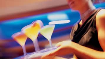Une personne tenant un plateau sur lequel se trouvent trois verres à cocktail.