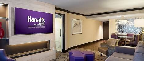 A Harrah's Atlantic City lobby with a large Harrah's sign, seating area, and a bar/lounge setup.