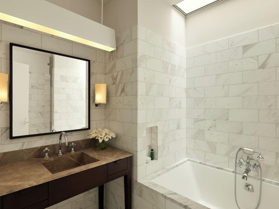 A modern bathroom with a marble sink, a large mirror, and a bathtub with a showerhead.