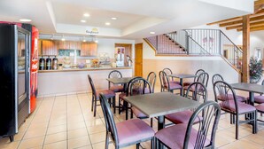 A restaurant with a counter, seating area, and a staircase. - Days Inn & Suites by Wyndham Lordsburg (Lordsburg)