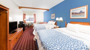 A hotel room with two beds, a TV, a desk with a chair, and a window with curtains. - Days Inn & Suites by Wyndham Lordsburg (Lordsburg)