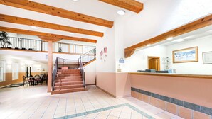 A hotel lobby with a staircase, a reception desk, and a dining area. - Days Inn & Suites by Wyndham Lordsburg (Lordsburg)