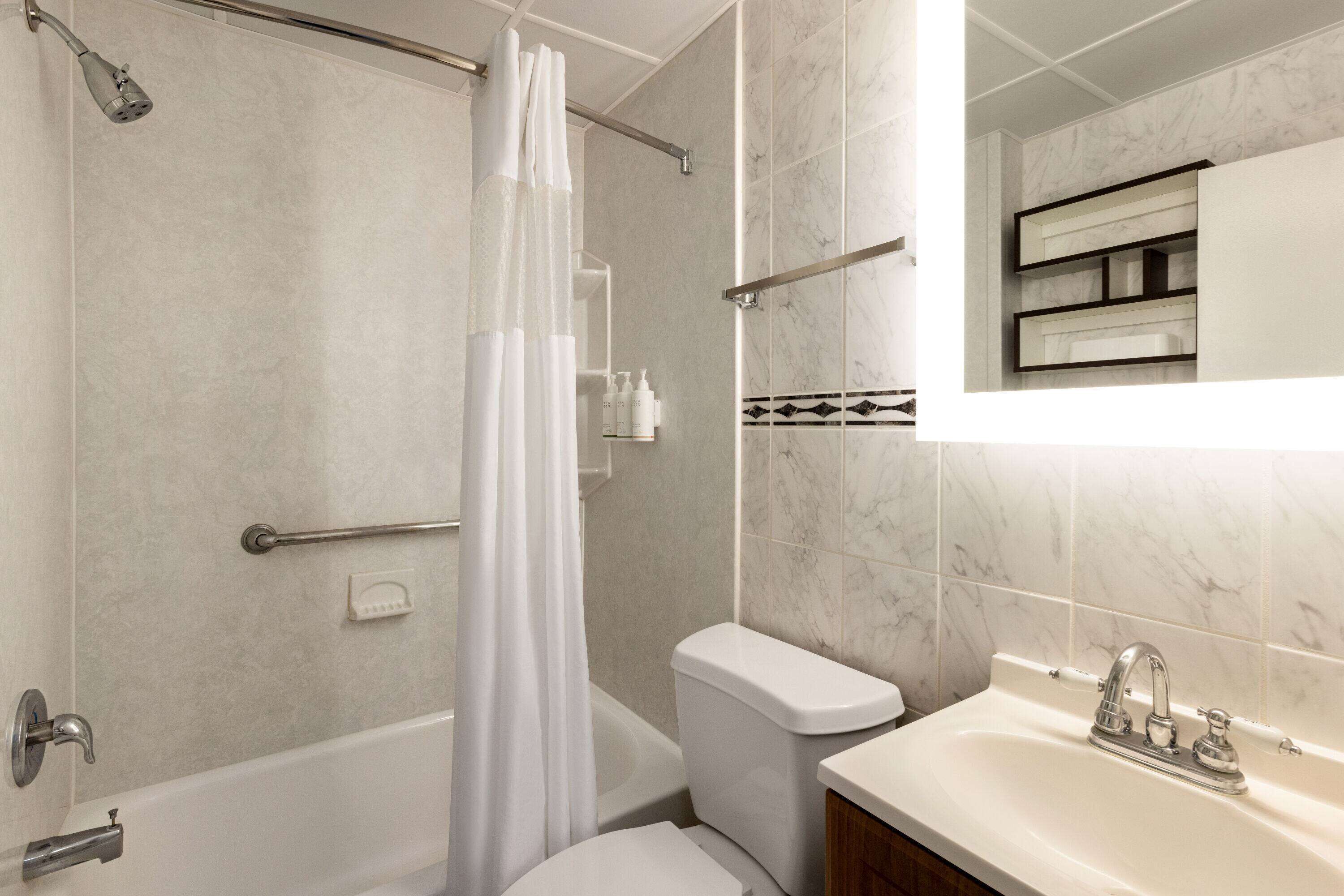 A modern bathroom with a bathtub, toilet, and sink.