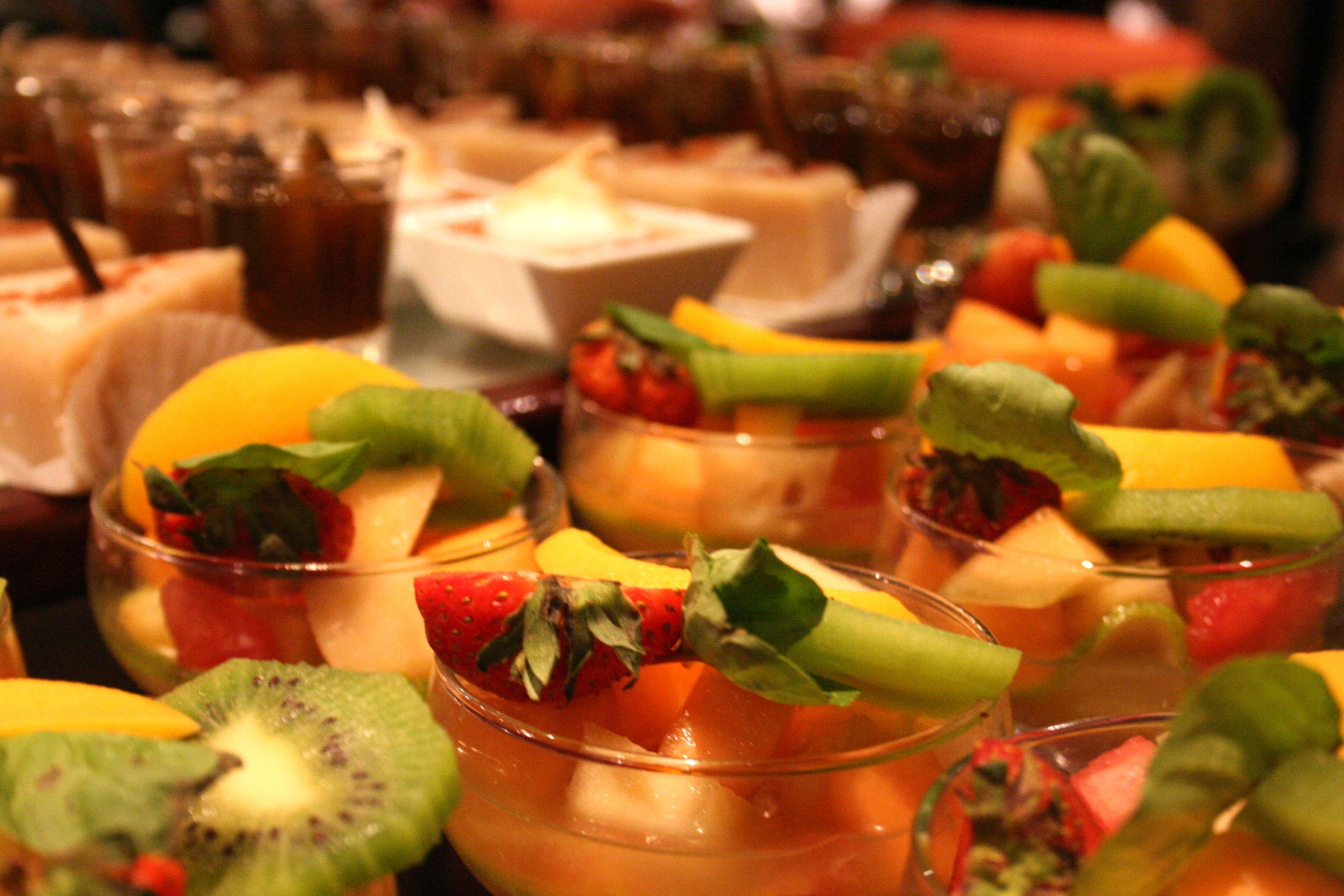 Verschillende fruitdesserts in glazen, op een tafel gerangschikt.
