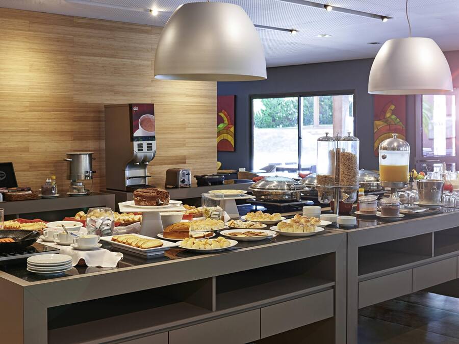 A buffet with various food items, a coffee machine, and a juice dispenser.