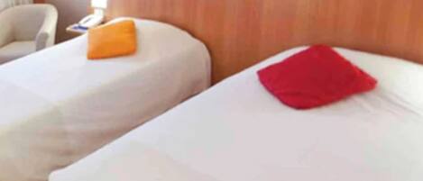 Una habitación de hotel con dos camas, cada una con un almohadón.