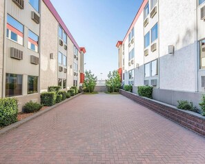 A pathway leading to a building with multiple windows and air conditioning units. - Quality Inn & Conference Centre Red Deer - 50th Avenue (Red Deer)