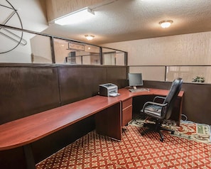 Oficina tipo cubículo con escritorio, silla, computadora e impresora.