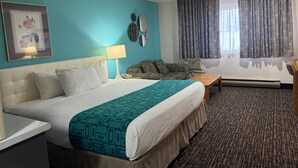Hotelkamer met een bed, een bureau, een stoel, een bank en een raam met gordijnen.