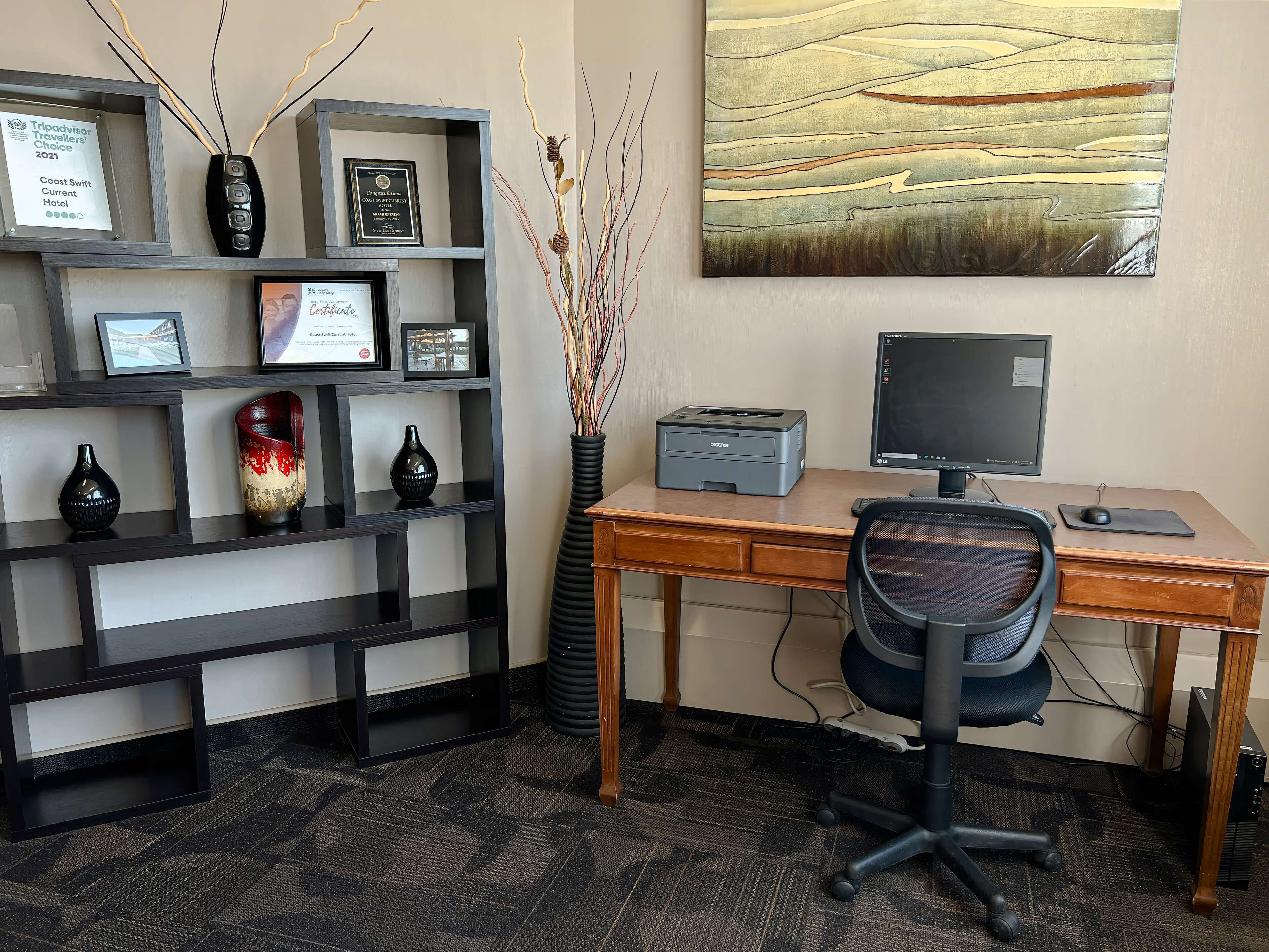 Un espacio de oficina moderno con un escritorio, una silla, un ordenador, una impresora y objetos decorativos en estanterías.