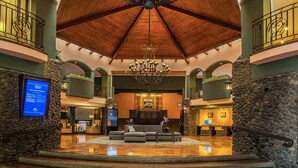 A lobby with a chandelier, stone walls, and a reception desk. - DoubleTree by Hilton Cariari - San Jose Costa Rica (La Asunción)