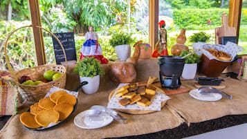 A table with food items, a basket of fruits, and decorative objects.