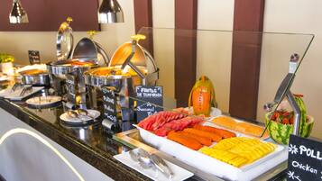 A buffet with various food options including fruits, vegetables, and a sign indicating pollard chicken.