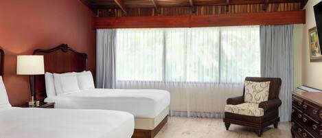 A hotel room with two beds, a wooden ceiling, a chair, and a dresser.