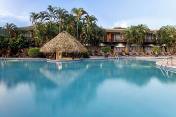 Una piscina al aire libre, sombrillas, sillones reclinables de piscina